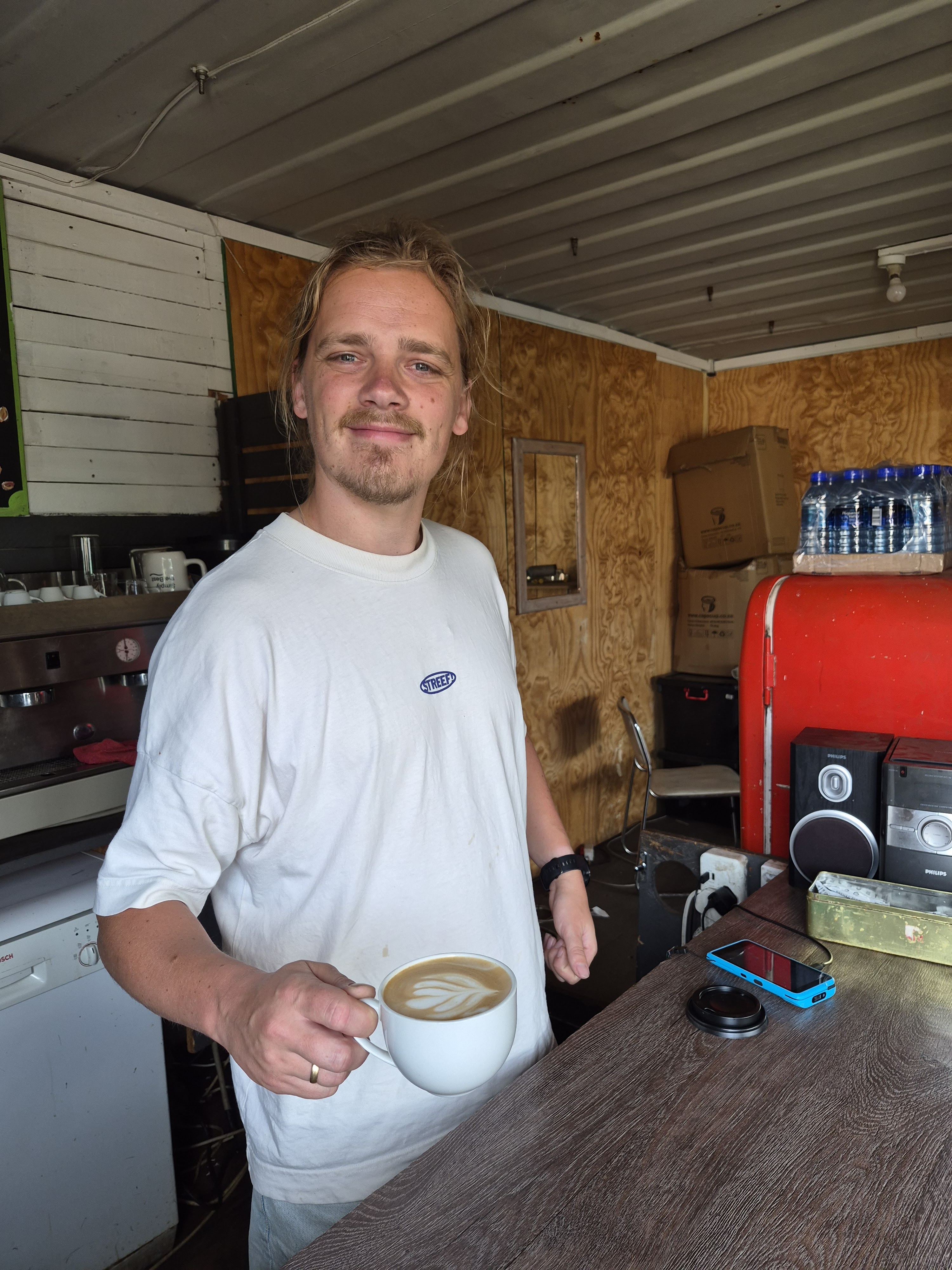Barista van Absoluukt bereidt een cappuccino met latte art in de mobiele koffiebar