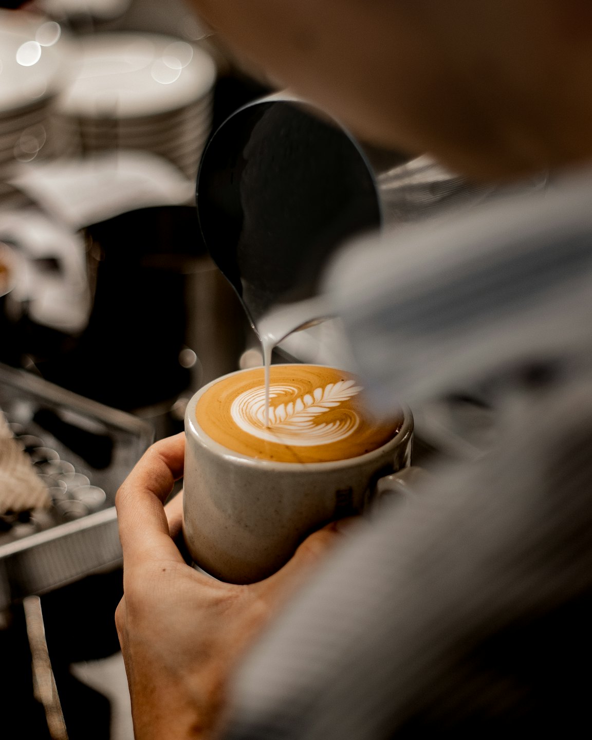 Close-up van latte art die gegoten wordt in een kopje cappuccino