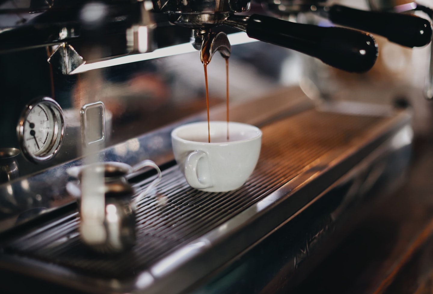 Verse espresso loopt uit de espressomachine in een kopje