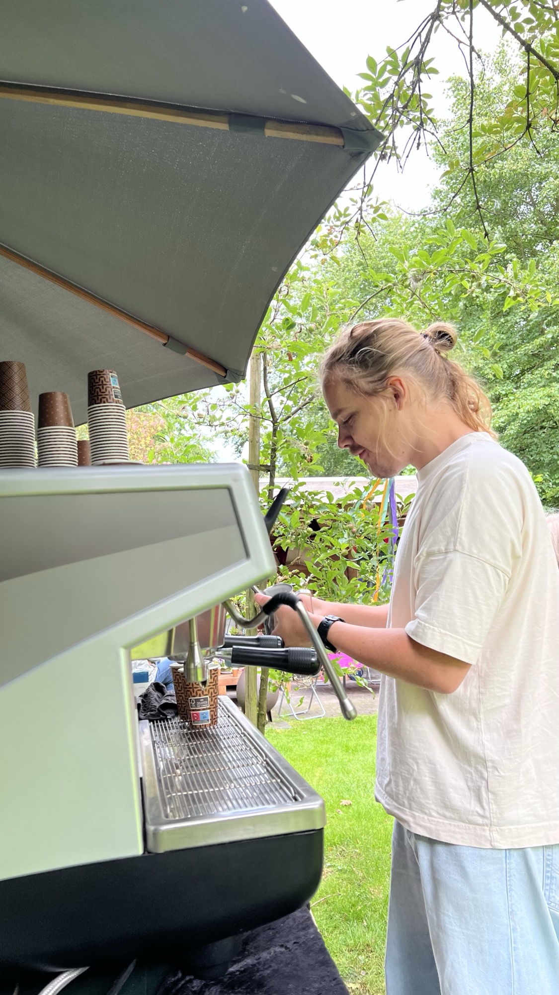 Barista van Absoluukt stoomt melk op met de espressomachine