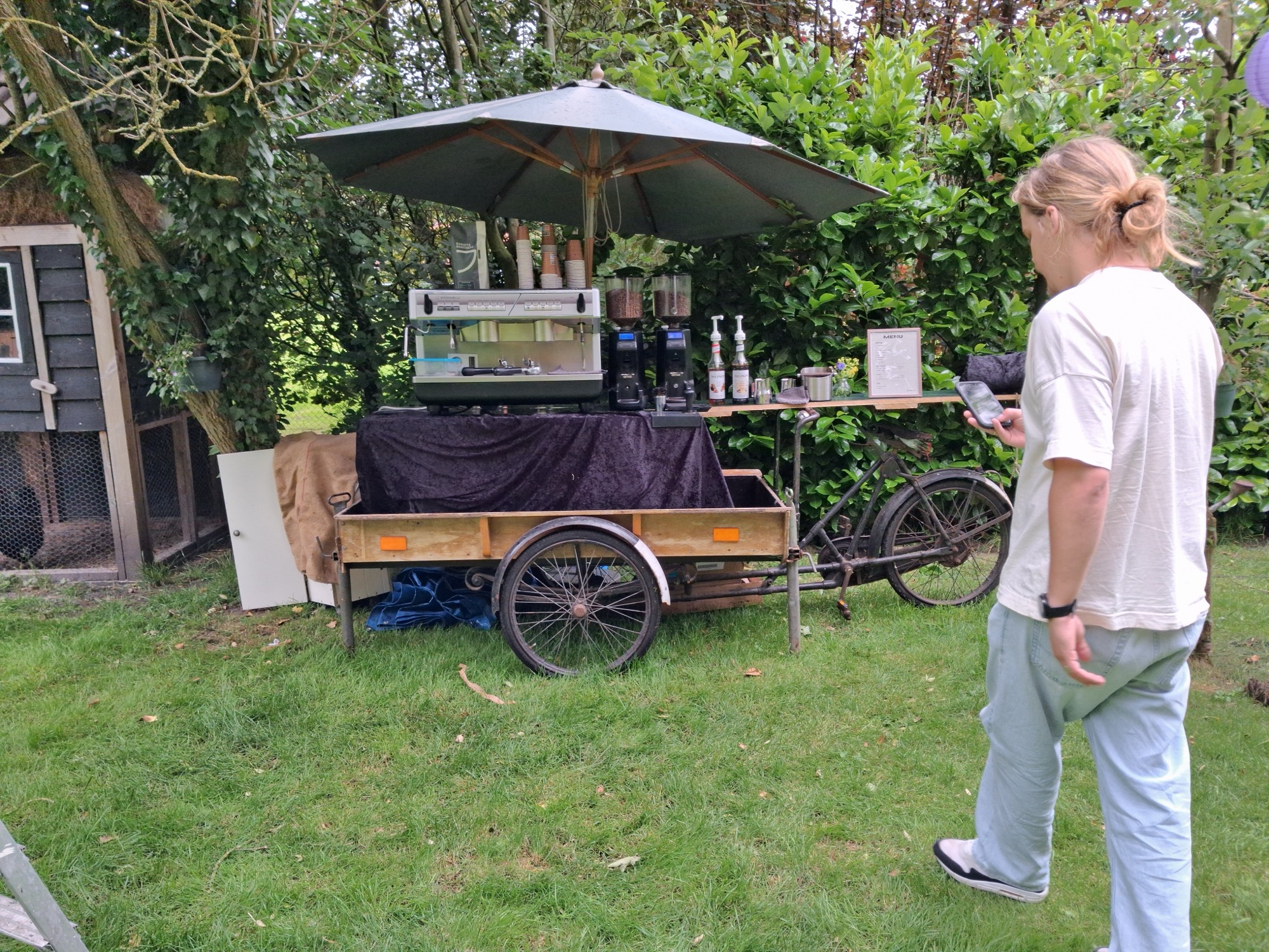 Mobiele koffiekar van Absoluukt volledig opgesteld met espressomachine en menubord tijdens een tuinfeest